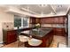 Modern kitchen featuring a large island, dark wood cabinets, and stainless steel appliances at 9170 Fox Fire Dr, Highlands Ranch, CO 80129