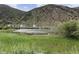 Scenic view of waterfront houses with mountain backdrop and tall grassy foreground at 1901 Clear Creek Dr # F104, Georgetown, CO 80444