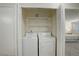 A laundry area closet contains a side-by-side washer and dryer setup with wire shelving above at 12281 E Tennessee Dr # 302, Aurora, CO 80012
