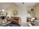 Comfortable living room with a supple brown leather sofa, desk, and a round mirror on a modern wall at 12281 E Tennessee Dr # 302, Aurora, CO 80012