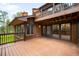 A large deck overlooks the wooded area behind the house, with sliding glass doors leading inside at 612 Nob Hill Trl, Franktown, CO 80116