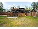 Expansive backyard with a large wooden house with multiple decks and patios at 612 Nob Hill Trl, Franktown, CO 80116
