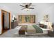 Bright bedroom features a ceiling fan, large windows, and neutral decor with a view of the surrounding forest at 612 Nob Hill Trl, Franktown, CO 80116