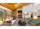 Inviting living room with stone fireplace, wood ceilings, and picturesque backyard views at 612 Nob Hill Trl, Franktown, CO 80116