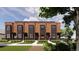 Brick townhouse exterior with black accents, small porches, and landscaped front yards at 115 W 2Nd Ave # 104, Denver, CO 80223