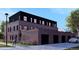 Exterior view of a brick building with black roof, multi-car garage and modern architecture at 115 W 2Nd Ave # 104, Denver, CO 80223