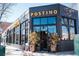Street-level view of Postino with large storefront windows and a modern, brick facade at 115 W 2Nd Ave # 104, Denver, CO 80223