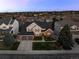 An aerial view of a charming two-story home with a three car garage, complemented by lush landscaping and a well-manicured lawn at 7862 Stonedale Dr, Castle Pines, CO 80108