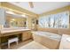 Luxurious bathroom featuring a soaking tub, vanity area, large window, and tiled floor at 7862 Stonedale Dr, Castle Pines, CO 80108