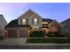 Charming two-story home featuring a three car garage, brick accents and a beautifully landscaped front yard at 7862 Stonedale Dr, Castle Pines, CO 80108