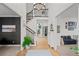 Grand foyer with beautiful hardwood floors, staircase with iron balusters, designer light fixture, and ample natural light at 7862 Stonedale Dr, Castle Pines, CO 80108