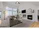 Bright living room with vaulted ceilings, a cozy fireplace, large windows, and a comfortable sectional sofa at 7862 Stonedale Dr, Castle Pines, CO 80108