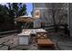 Outdoor patio with fire pit and seating area, shaded by an umbrella at 7862 Stonedale Dr, Castle Pines, CO 80108