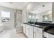 Luxurious bathroom with sleek walk-in shower, dual sink vanity with dark countertops, and large windows at 1840 Morgan Dr, Erie, CO 80516