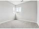 This bedroom includes neutral carpet and walls, plus a pair of windows at 1840 Morgan Dr, Erie, CO 80516