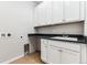 Functional laundry room with ample cabinet space, sink, and durable flooring at 1840 Morgan Dr, Erie, CO 80516
