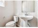 The powder room features a pedestal sink, modern fixtures and a window for natural light at 1840 Morgan Dr, Erie, CO 80516