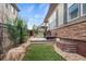 The landscaped backyard features lush green grass, a patio, and stone accents at 7790 S Queensburg Way, Aurora, CO 80016