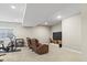 Spacious basement with comfortable seating, a large-screen TV, and workout area offering versatility at 7790 S Queensburg Way, Aurora, CO 80016