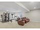 Finished basement with a home gym, relaxing seating, and a neutral color scheme providing comfort at 7790 S Queensburg Way, Aurora, CO 80016