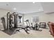 Large basement showcasing a home gym with various equipment, including a treadmill and weight machines at 7790 S Queensburg Way, Aurora, CO 80016