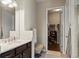 Bathroom with dual sinks, granite counters, a separate walk-in closet and storage at 7790 S Queensburg Way, Aurora, CO 80016