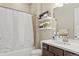 Functional bathroom with shower-tub combo, updated vanity, and decorative shelves for storage and style at 7790 S Queensburg Way, Aurora, CO 80016