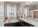Elegant bathroom featuring a soaking tub, granite countertops, and ample counter space at 7790 S Queensburg Way, Aurora, CO 80016