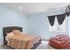 Serene bedroom painted with light blue walls and a red, patterned bedspread over a queen bed at 7790 S Queensburg Way, Aurora, CO 80016