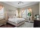 Inviting bedroom with a plush rug, tray ceiling, and ample natural light from the large windows at 7790 S Queensburg Way, Aurora, CO 80016