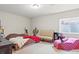 Inviting bedroom setup for flexible use, featuring a couch, double bed and window with natural light; cozy and versatile at 7790 S Queensburg Way, Aurora, CO 80016