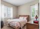 Cozy bedroom with natural light from two windows, complemented by a comfortable bed and neutral decor at 7790 S Queensburg Way, Aurora, CO 80016
