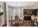 Bright dining area with hardwood floors, a modern chandelier, and a glass table perfect for entertaining at 7790 S Queensburg Way, Aurora, CO 80016