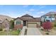 Charming single-Gathering home with brick accents, a well-manicured lawn, and a two-car garage at 7790 S Queensburg Way, Aurora, CO 80016