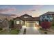 Beautifully landscaped home exterior with a stone facade and a well-maintained lawn at 7790 S Queensburg Way, Aurora, CO 80016