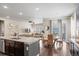 Open-concept kitchen and dining area with granite countertops, stainless appliances, and hardwood floors at 7790 S Queensburg Way, Aurora, CO 80016