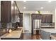Well-equipped kitchen with granite countertops, stainless steel appliances, and ample dark wood cabinetry at 7790 S Queensburg Way, Aurora, CO 80016