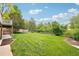 Expansive backyard with a lush lawn, wooden fence, and mature trees at 11285 Ranch Pl, Denver, CO 80234
