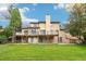 Expansive backyard featuring a large deck, lush green lawn, and mature trees at 11285 Ranch Pl, Denver, CO 80234