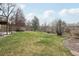 Lush backyard features a spacious lawn, mature trees, and a charming wooden fence, enhancing privacy and appeal at 11285 Ranch Pl, Denver, CO 80234