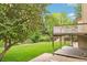 Expansive backyard with a lush lawn, mature trees, and a charming deck at 11285 Ranch Pl, Denver, CO 80234