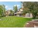 Expansive backyard with a lush lawn, mature trees, and a charming deck at 11285 Ranch Pl, Denver, CO 80234