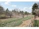 Scenic backyard view featuring a natural landscape with trees and a wooden fence at 11285 Ranch Pl, Denver, CO 80234