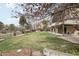 Expansive backyard with manicured lawn, mature trees, patio, and upper level deck at 11285 Ranch Pl, Denver, CO 80234