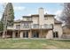 Backyard view showcasing a two-story home with decks, a lawn, and mature trees at 11285 Ranch Pl, Denver, CO 80234