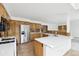 Spacious kitchen with wood cabinets, stainless steel appliances, a center island, and ample counter space at 11285 Ranch Pl, Denver, CO 80234