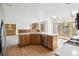 Bright and open kitchen featuring a center island with a sink, stainless steel appliances, and wood-style flooring at 11285 Ranch Pl, Denver, CO 80234