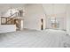 Spacious living area with vaulted ceilings, a staircase, neutral carpet, and ample natural light from large windows at 11285 Ranch Pl, Denver, CO 80234