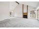 Open-concept living room featuring vaulted ceilings, a fireplace, neutral carpet, and plenty of natural light at 11285 Ranch Pl, Denver, CO 80234