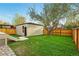 Spacious backyard with lush lawn, stone pavers, a detached garage, and a privacy fence at 2391 Hudson St, Denver, CO 80207